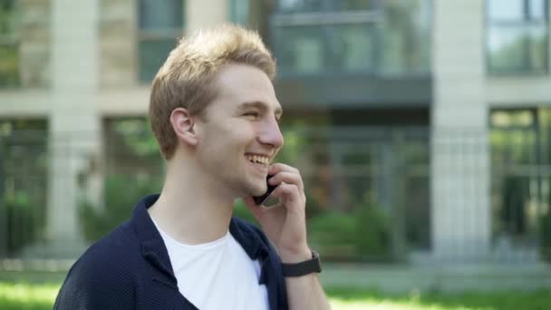 Чоловік розмовляє по телефону і підморгує — стокове відео