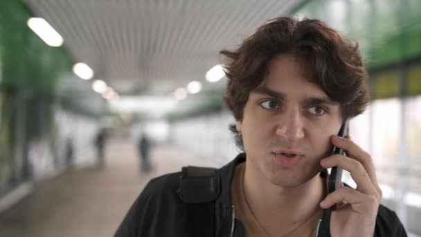 Schöner junger Mann, der auf dem Smartphone spricht — Stockvideo