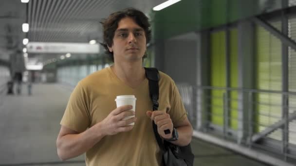 Selbstbewusster junger Mann geht mit Coffee to go — Stockvideo