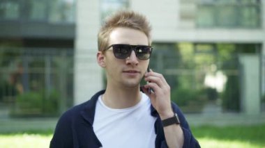 Adam telefonda konuşurken ve wow söyleyerek güneş gözlüğü