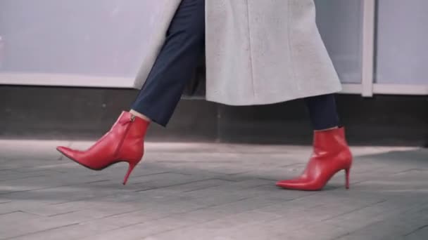在秋街散步的无法辨认的穿着红色靴子的女人的腿 — 图库视频影像