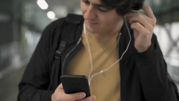 Hombre poniéndose auriculares y escuchando música — Vídeo de stock