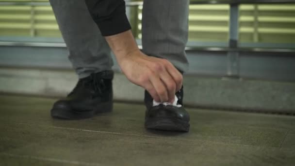 Hombre limpiando sus zapatos con una servilleta — Vídeos de Stock