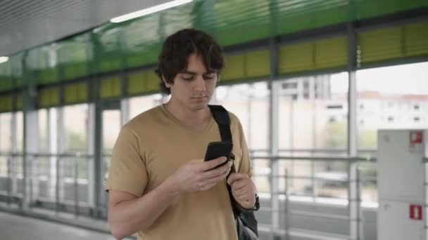 Joven marcando un número y hablando por teléfono mientras camina — Vídeo de stock