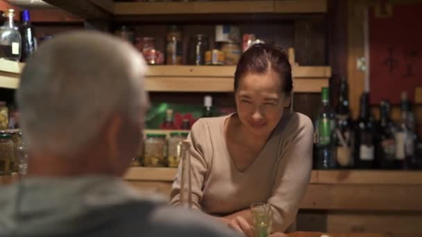 Азиатская женщина средних лет пьет вино со своим мужем — стоковое видео