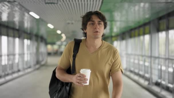 Joven con bolsa caminando con café — Vídeos de Stock