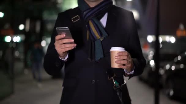 慢动作中拍摄男性手与电话和咖啡 商人拿着一杯咖啡和智能手机的休闲造型 没有脸上的云台镜头 — 图库视频影像