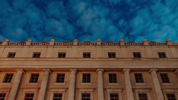 Timelapse de un edificio de fachada. Las nubes sobrevuelan el edificio. amanecer . — Vídeos de Stock