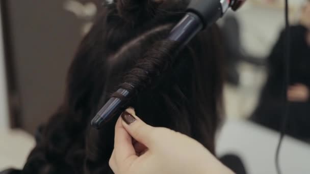 Curling iron y hebra de cabello oscuro en proceso — Vídeo de stock