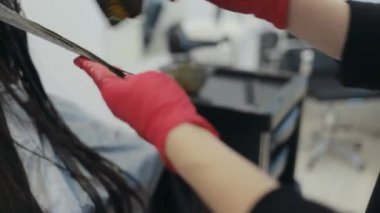 Esmer bir kadın bir iplikçik boyama Kuaför Close-Up
