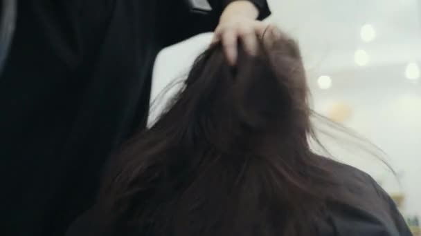 Coiffeur séchage des cheveux de la femme brune dans le salon — Video