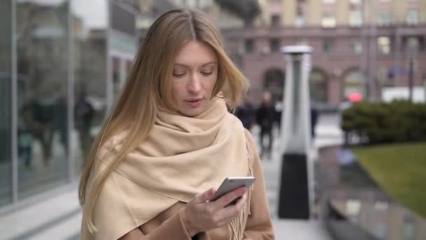 Zakenvrouw lezen van tekst op de telefoon tijdens het lopen — Stockvideo