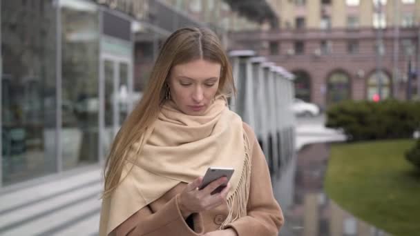 Zakenvrouw lezen van tekst op de telefoon tijdens het lopen — Stockvideo