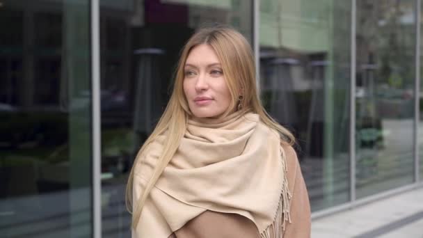 Jolie femme vêtue d'un manteau d'automne debout dans la rue — Video