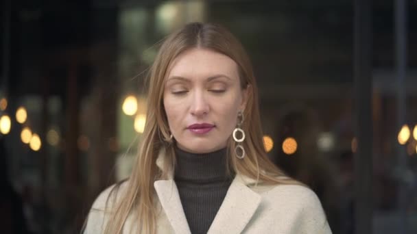 Belle femme en manteau blanc buvant du café en regardant la caméra — Video