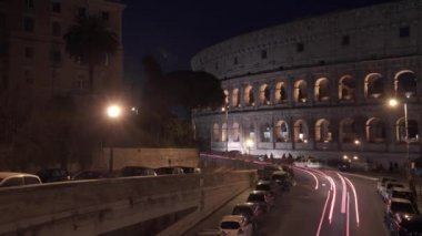 Sola doğru Timelapse gece trafik Colosseo, Roma yakın atış pan. Colosseum Flavian amfi olarak da bilinir. Oval bir amfiteatr, Roma, İtalya'nın şehir merkezinde