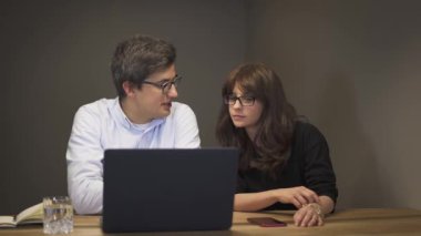 Dizüstü bilgisayar önünde bir konuşma olan iş ortakları