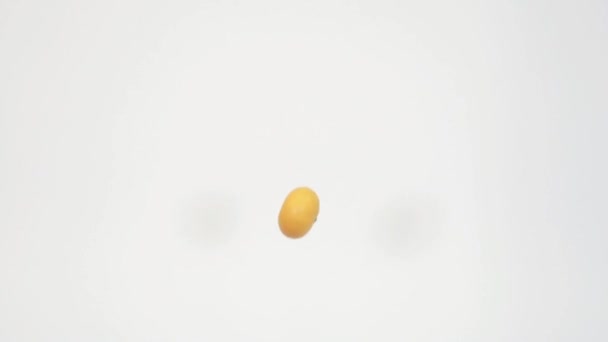 Mouvement lent de nombreuses mandarines lancées en l'air sur fond blanc 