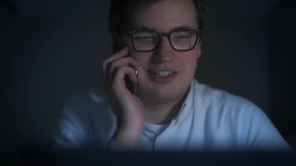 Pan schot van glimlachen jonge zakenman met een gesprek op moment van de nacht — Stockvideo