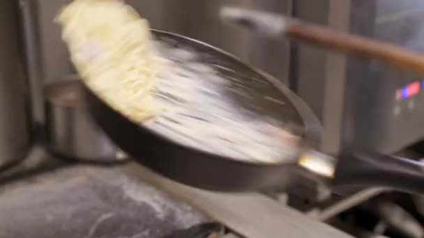 Cozinhe e jogue espaguete com molho de queijo e fritar bacon picado na panela quente — Vídeo de Stock