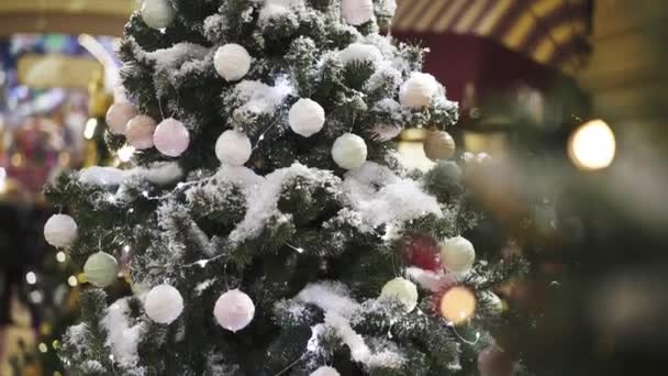 Árbol de Navidad con nieve artificial decorado con juguetes de árbol de Navidad blanco — Vídeo de stock