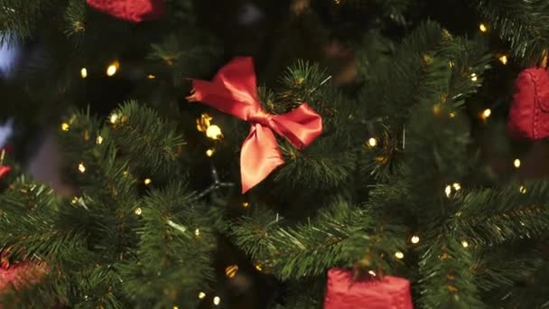 Close up of ribbons and christmas decorations on artificial fir tree — Stock Video