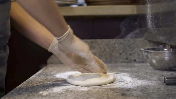 Итальянский повар готовит тесто на кухонном столе и месит его руками. — стоковое видео