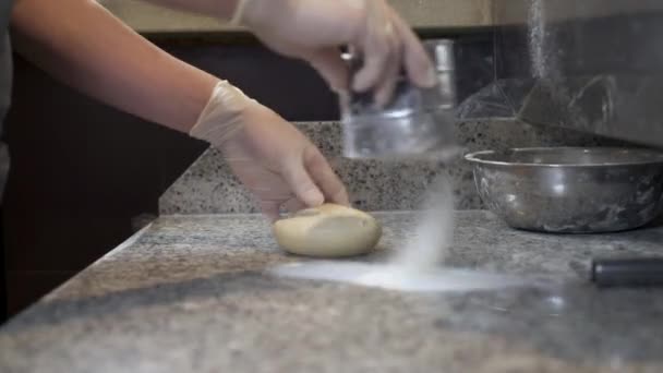 Cozinhe a farinha de polvilhar na massa e na superfície da mesa de cozimento para amassar — Vídeo de Stock