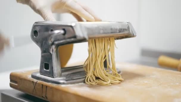 Närbild av färsk spaghetti pasta kommer ut ur pastamaskin — Stockvideo