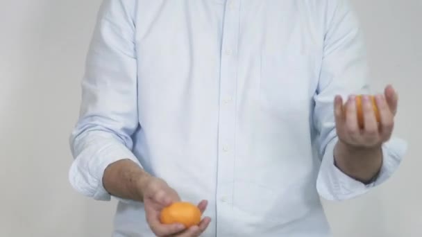 Mãos masculinas em câmara lenta a fazer malabarismos com três tangerinas. Sem rosto. — Vídeo de Stock