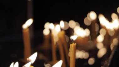 Ağır çekim el bulanık candels arka plan üzerinde yanan bir mum shot düzenlenen