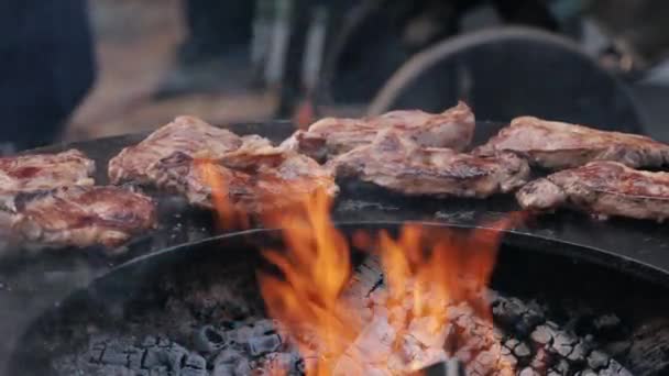 Pečené vepřové steaky na litině kulatý gril během pouliční trh — Stock video