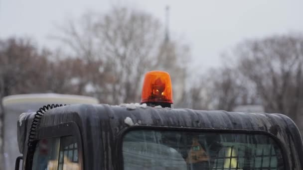 Toma de mano de luz naranja giratoria de emergencia en un automóvil en movimiento — Vídeos de Stock