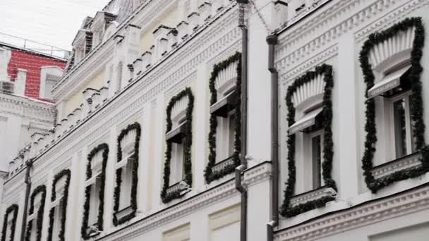 Janelas brancas em casas antigas decoradas com ouropel verde para o Ano Novo em Moscou — Vídeo de Stock