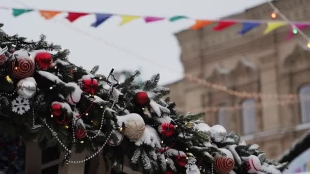 МОСКВА, РОССИЯ - ДЕКАБРЬ: Искусственная ветвь ели с рождественскими бусами и шариками на крыше дома — стоковое видео