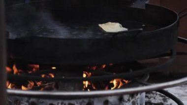 Siyah kauçuk eldivenle bir aşçı eli bir kürek ile bir pancake üzerinde dönüm.