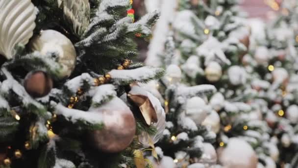 Bronze christmas balls hanging on artificial fir trees outside in winter — Stock Video