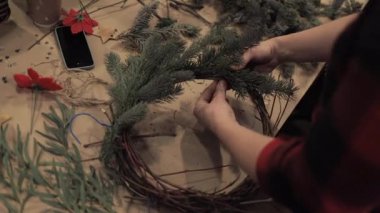 Kadın elleri noel çelengi üzerinde çam dalları kadar sıkma
