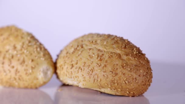 Close-up van twee sesam broodjes op roterende tafel — Stockvideo