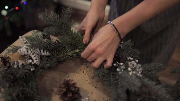 Gros plan des mains féminines tissant une couronne à partir d'une tige de bois — Video