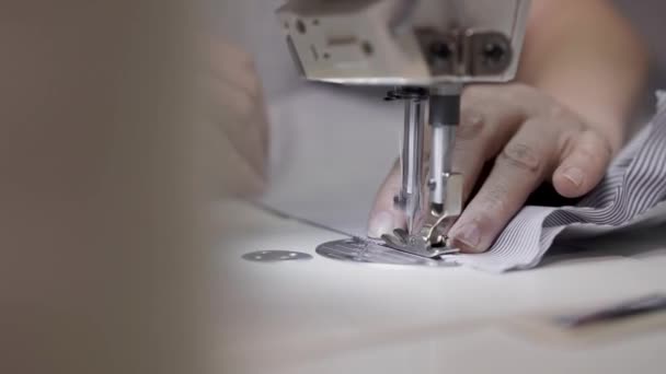 Крупный план ручной съемки взрослых женских рук со стороны шитья полосатой ткани — стоковое видео