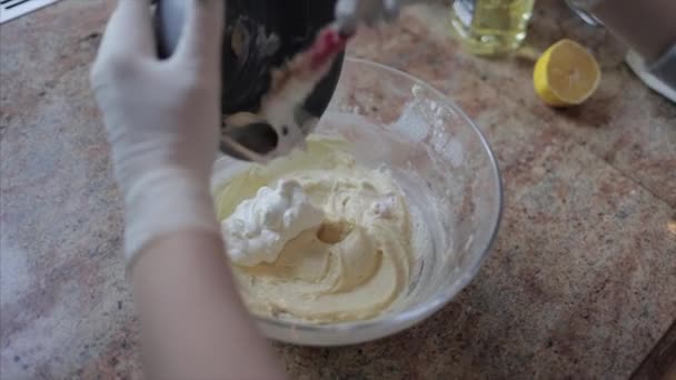 Přidávání bílých krémů do těsta ve skleněné misce — Stock video