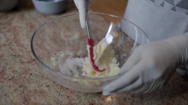 Готовить руки в белых резиновых перчатках, смешивая масло с сахаром — стоковое видео