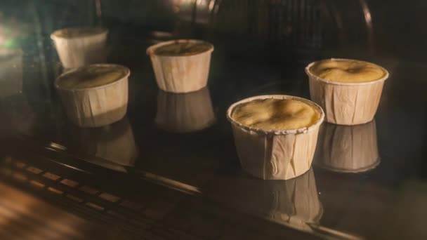 Πέντε κεκάκια σε λευκές καλούπια τούρτας που ψήνοντας στο εσωτερικό του φούρνου — Αρχείο Βίντεο