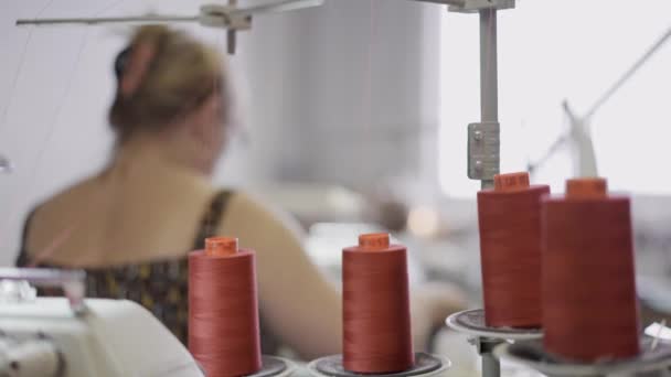 Close up of four orange spools of thread on background of seamstress woman — Stock Video