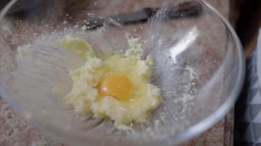 Şeker ve tereyağı krema ile cam kase içine bir yumurta kırmak kapatın