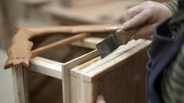 Pegamento endurecido raspado a mano masculino en la parte inferior de la caja de anidación de madera — Vídeo de stock