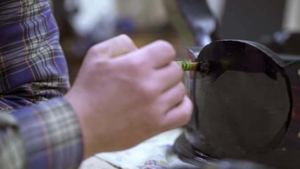 Close up shot of male hand refinishing antique cupboard with black paint — Stock Video