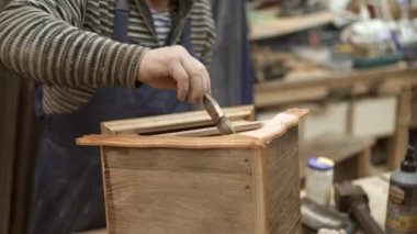 Ahşap atölyesinde erkek el vernikleme el yapımı yuvalama kutusu çatı