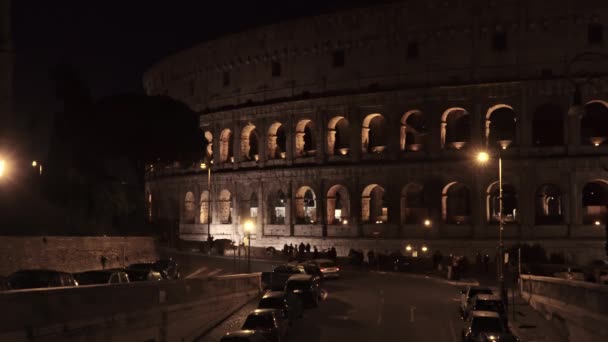 Zárt le valós idejű lövés az éjszakai forgalom közelében a Colosseo Rómában. A Colosseum más néven a flavian amfiteátrum, egy ovális amfiteátrum a város központjában Róma, Olaszország — Stock videók